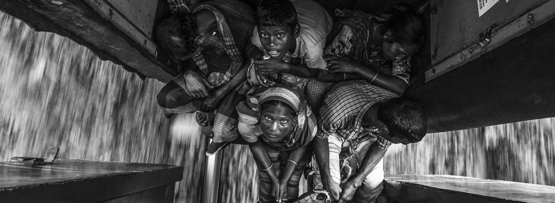 Passengers squeezed between train carriages, looking up