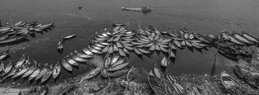 Rows of wooden boats moored on the river, seen from above